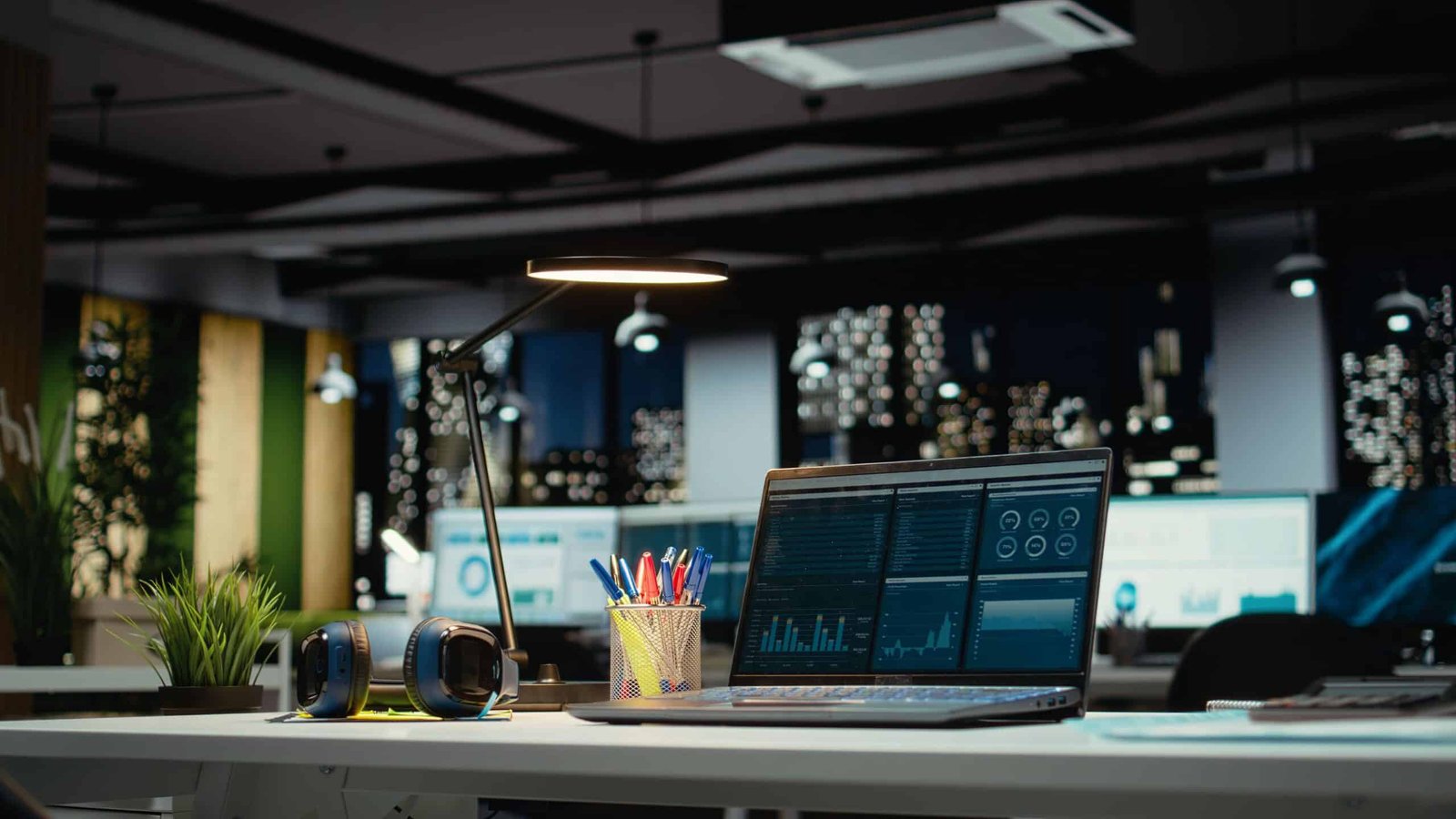 Oficina moderna con laptop mostrando dashboard de sistema de gestión empresarial