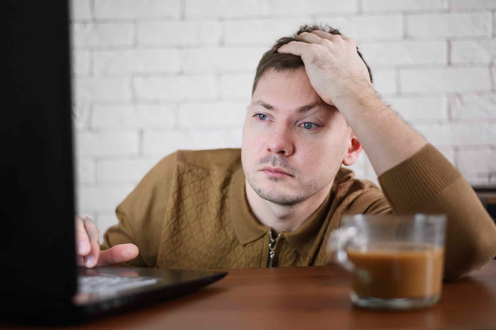 Hombre frustrado frente a computadora por sitio web lento